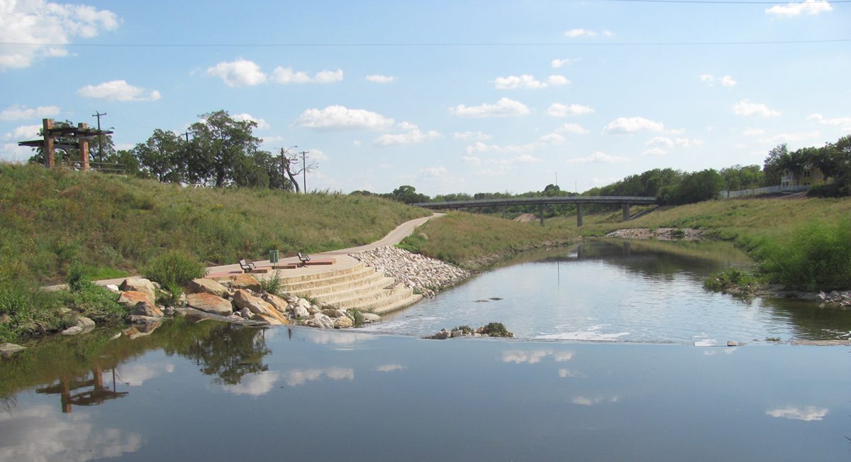 A body of water with rocks and trees in the background.