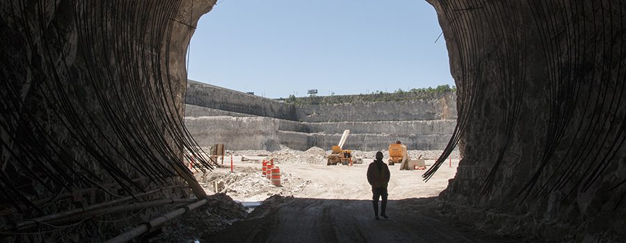 A man standing in front of an open pit.