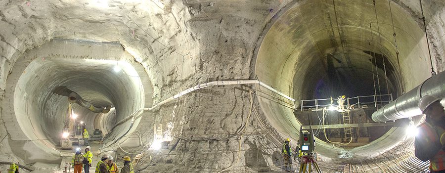 A tunnel with a lot of concrete and a person standing in the middle.